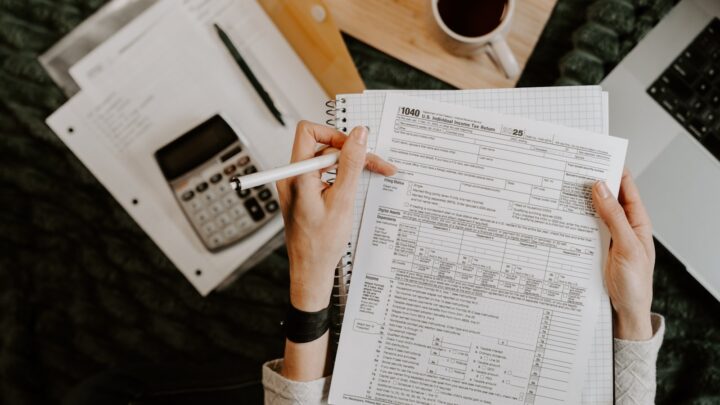 A person completing paperwork at a desk