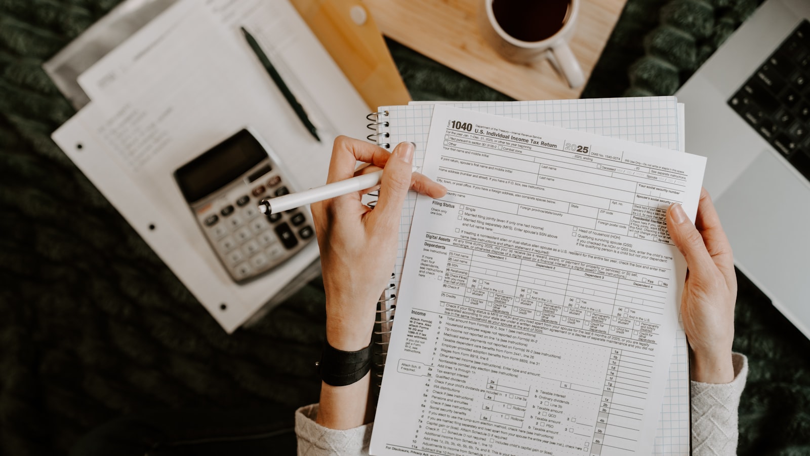 A person completing paperwork at a desk