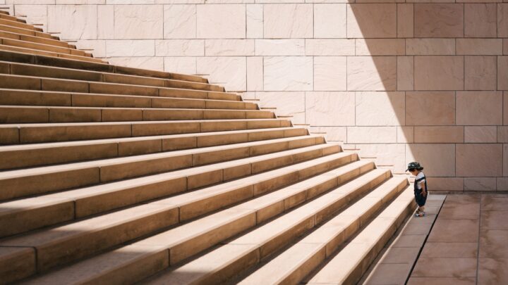 A wide stone staircase rising between plain walls