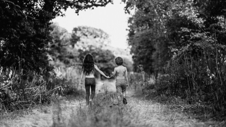 A small child's hand held by an adult's hand while walking