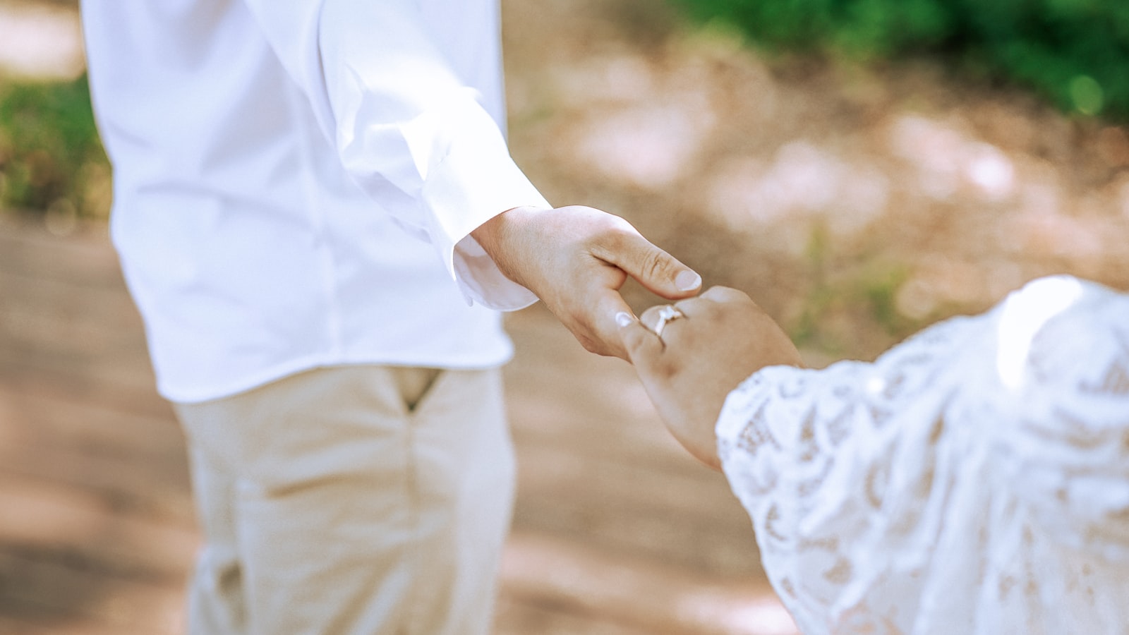 A young child holding an adult's hand while walking outside