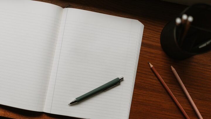 A fountain pen lying on a polished wooden desk
