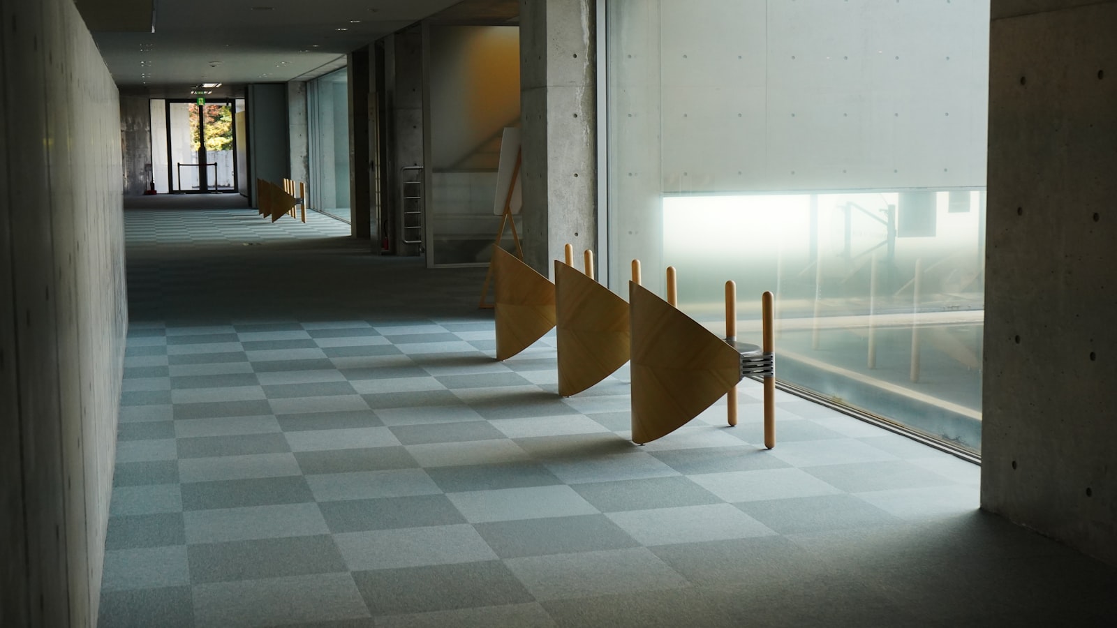 An empty wooden bench along a quiet corridor