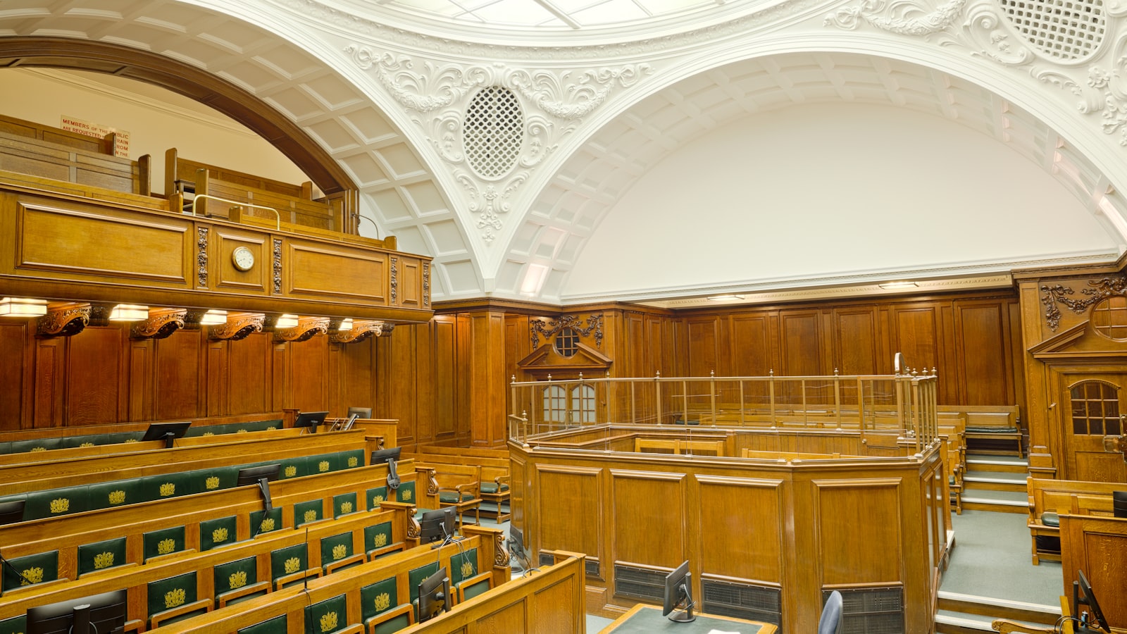 The interior of an empty courtroom with wooden benches