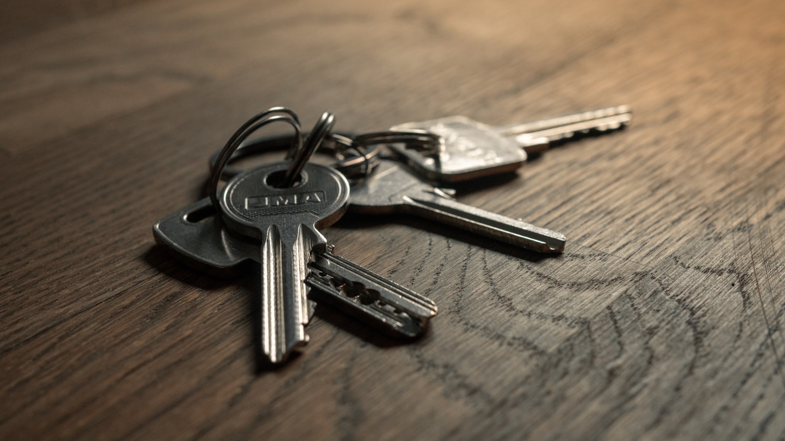 A set of house keys resting on a plain concrete surface