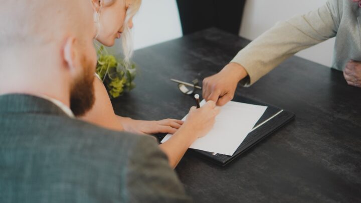 Two people signing a legal agreement, representing a deed of separation in Singapore