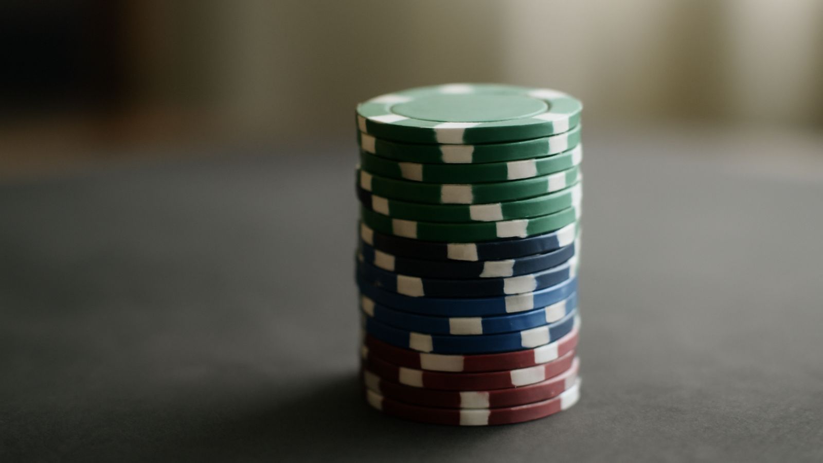 A stack of casino chips resting on a dark surface