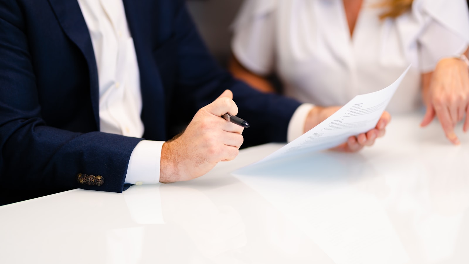 Two people sitting at a table signing a document