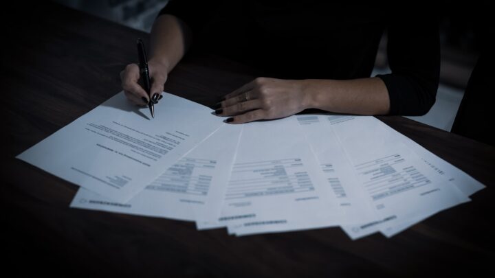 Stack of legal documents on a desk with a pen