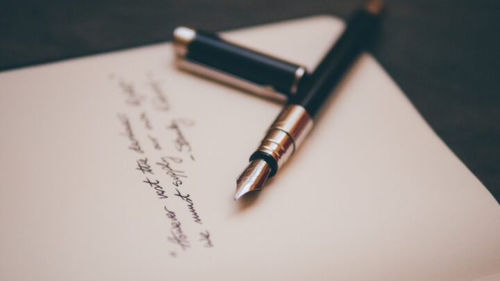 A fountain pen resting on a closed document folder
