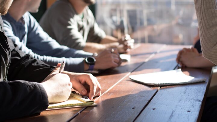 Two people in discussion across a meeting room table
