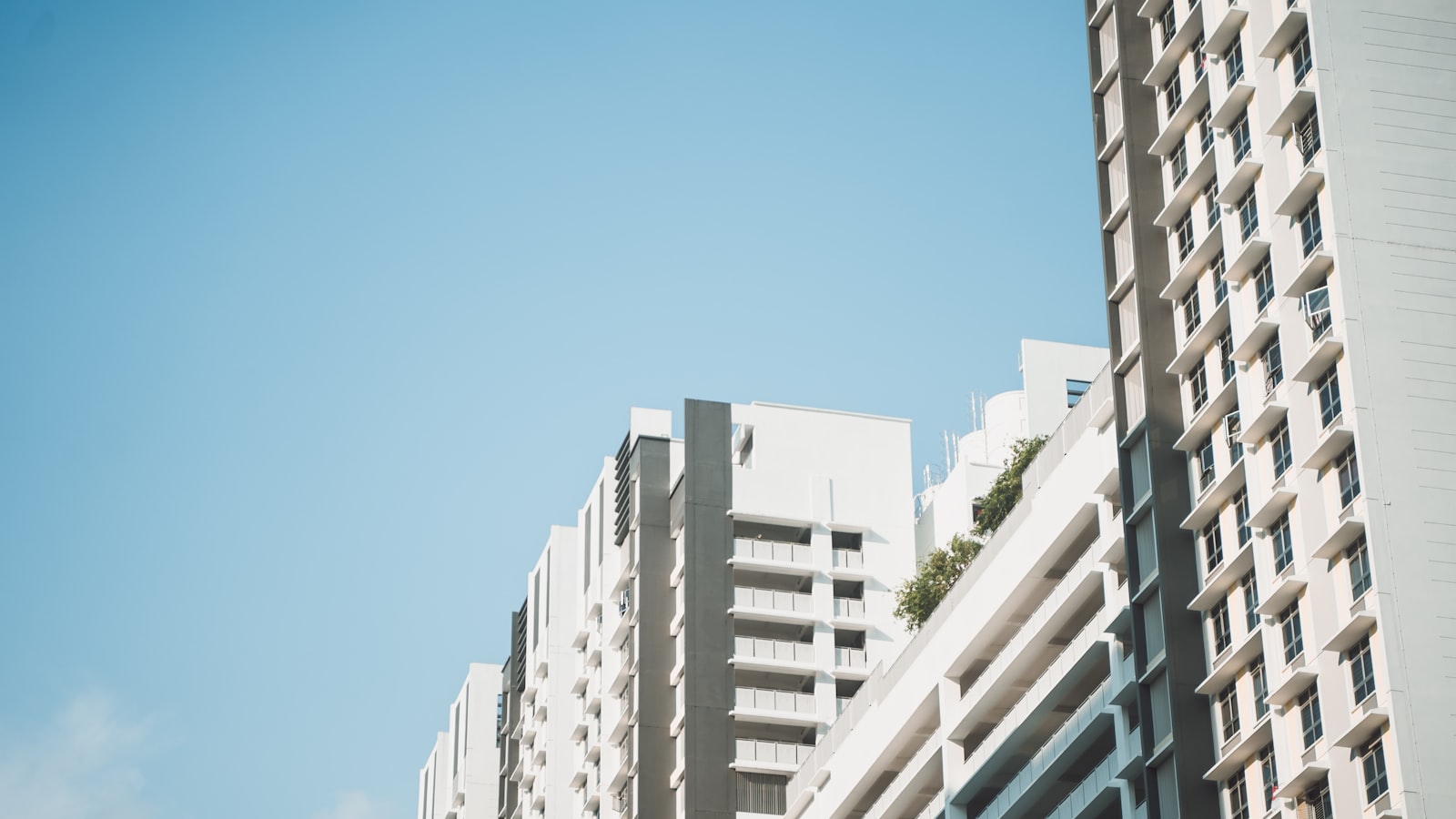 Singapore public housing blocks photographed from below against a clear sky