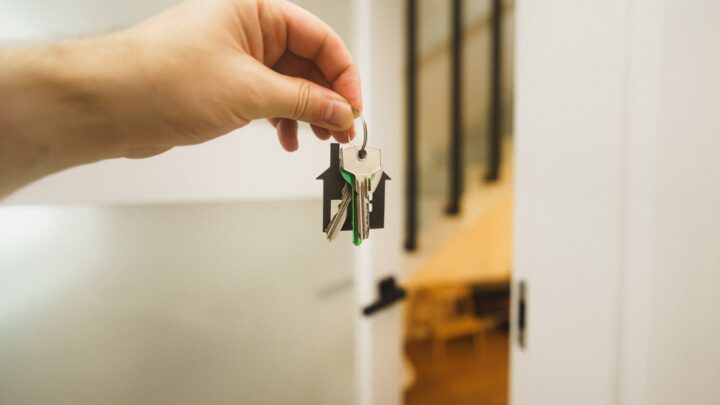 A close-up of a hand holding keys at an apartment door
