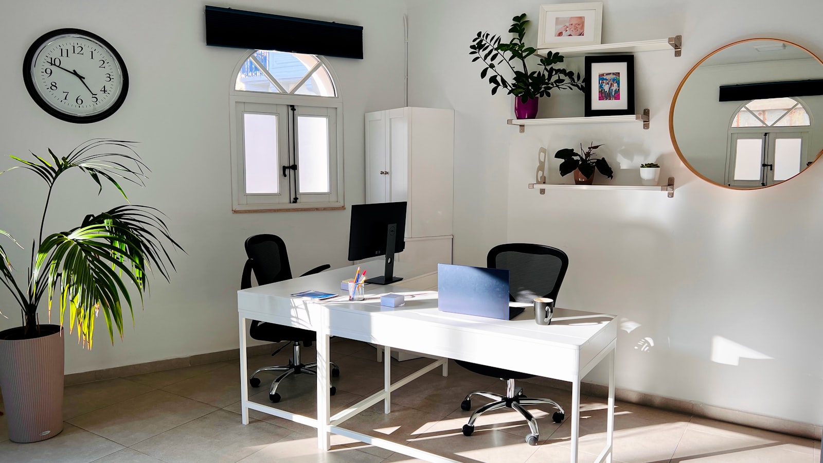 A wall clock beside a calendar in a bright room