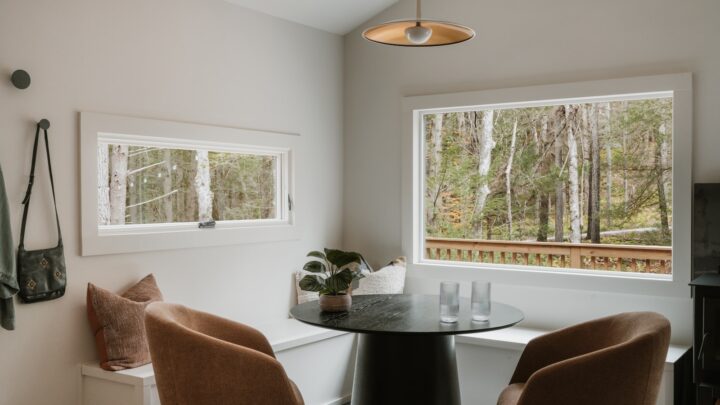 Two empty chairs at a small dining table beside a window