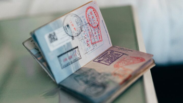 A passport and a set of keys on a plain wooden table