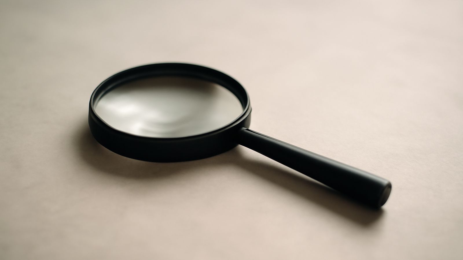 A magnifying glass resting on a plain surface