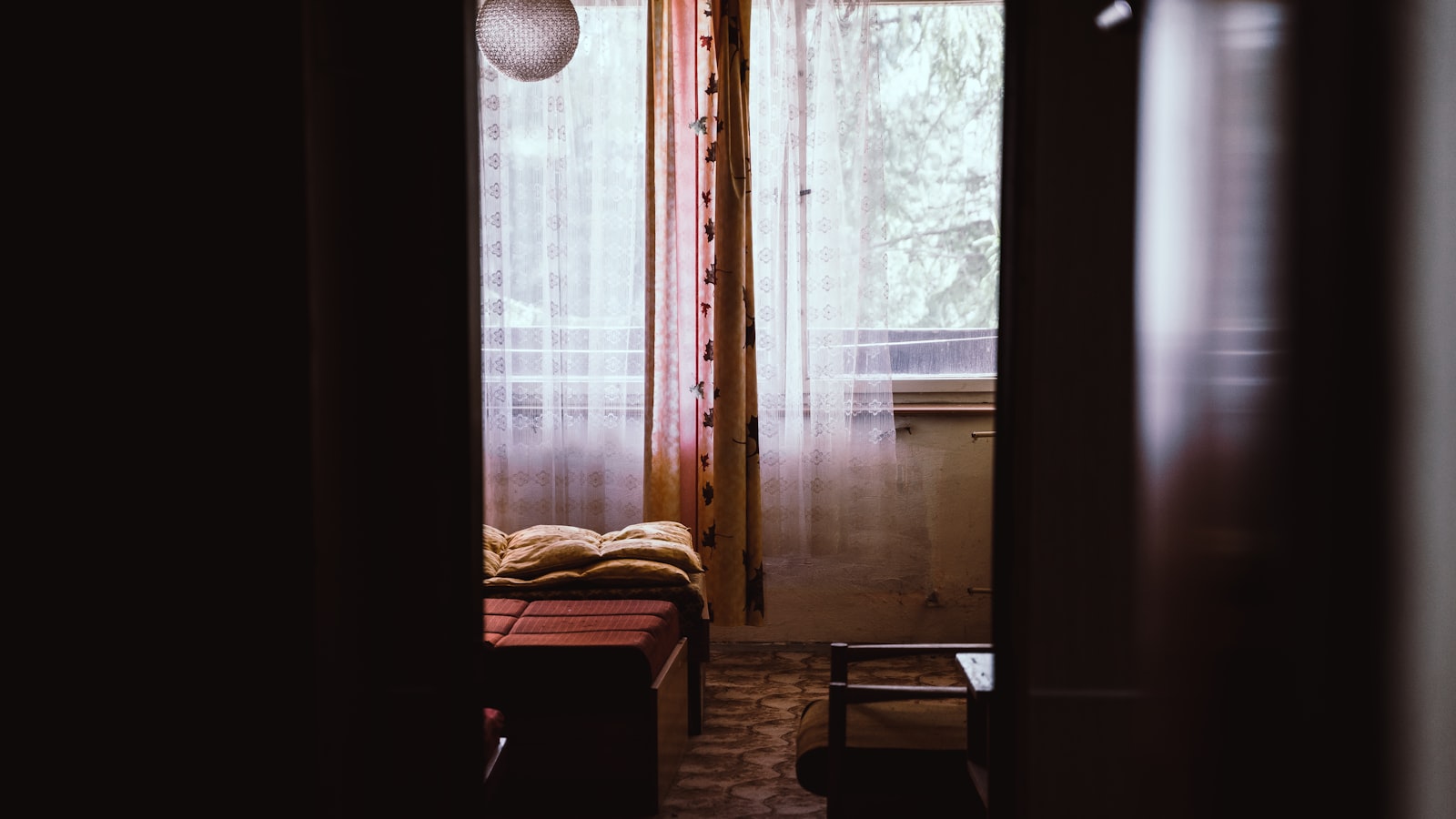 An empty wooden chair beside a window