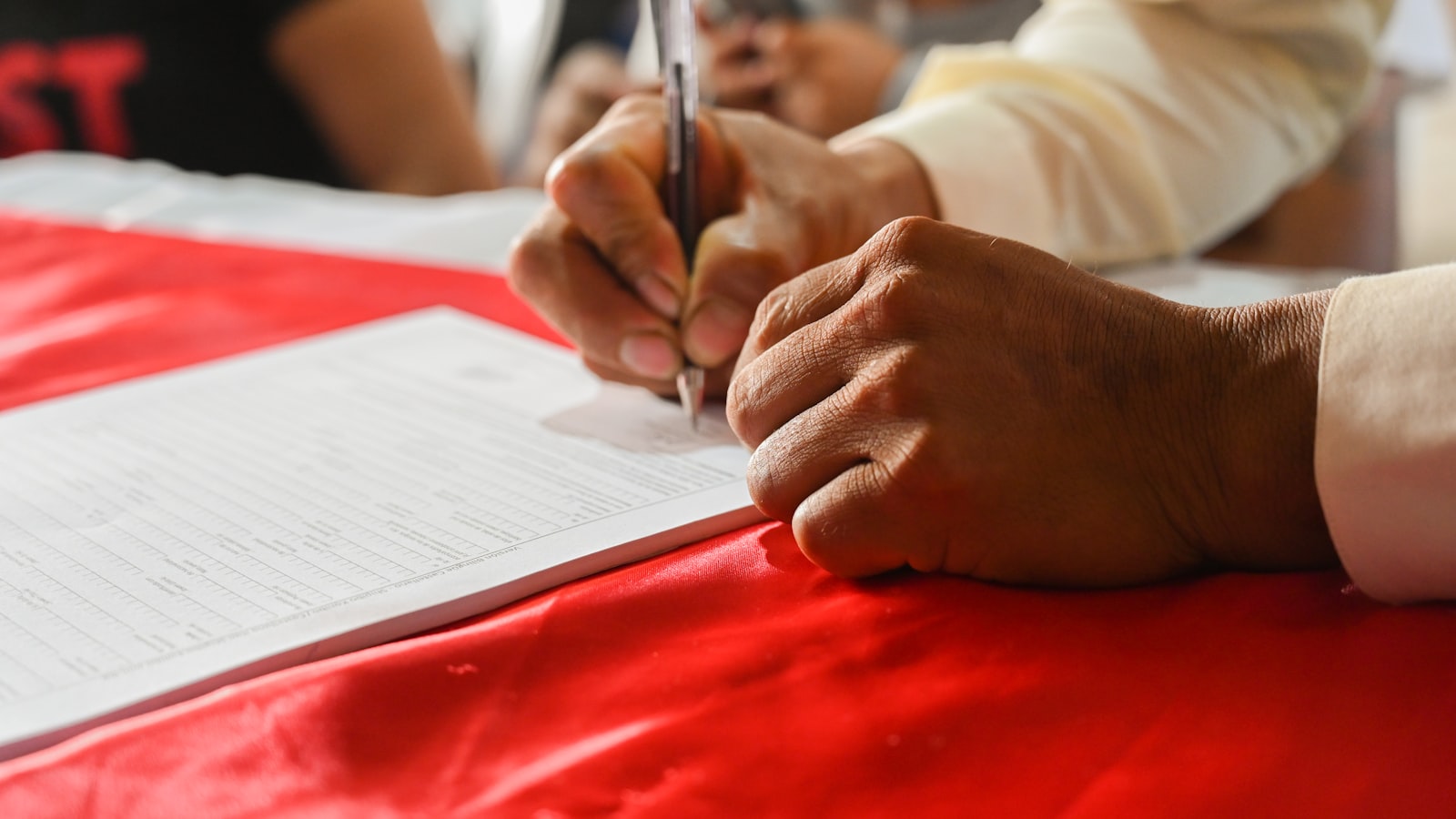 An older person signing a legal document in Singapore
