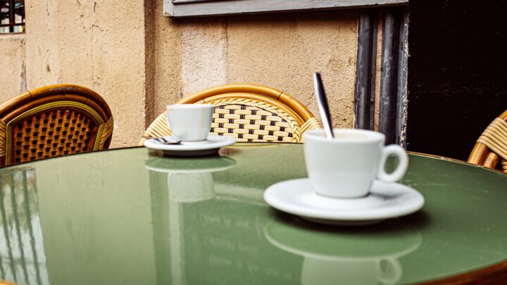 Two coffee cups on a small cafe table