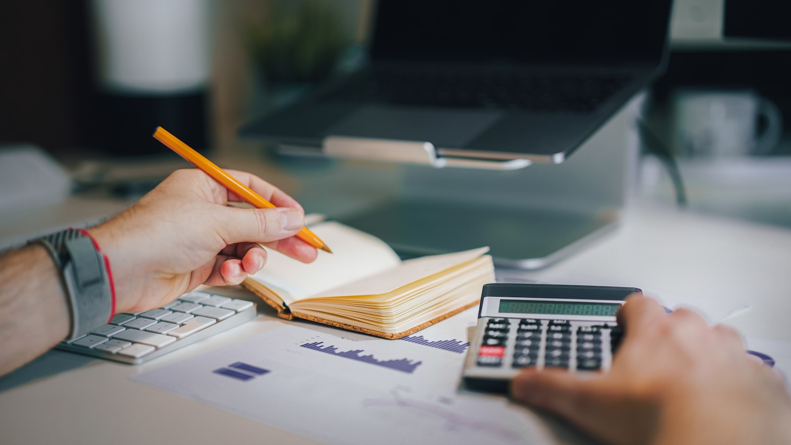 A desk with a calendar and bank statements laid out