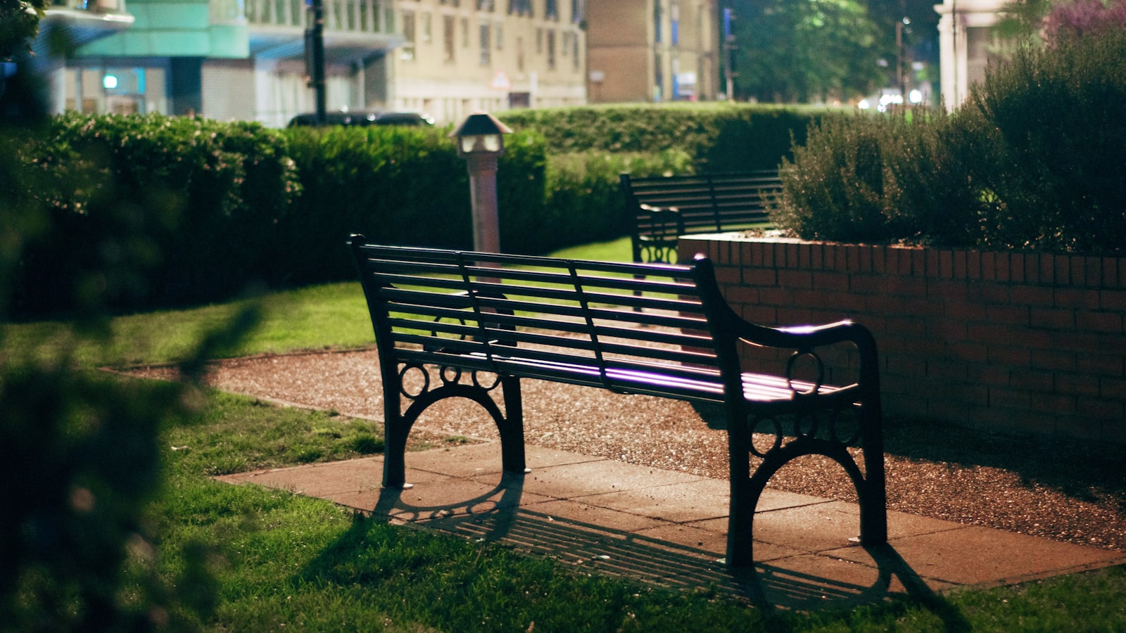 An empty wooden bench in a quiet park at dusk