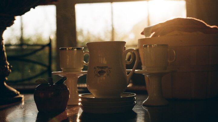 Two cups of coffee on a table next to a window