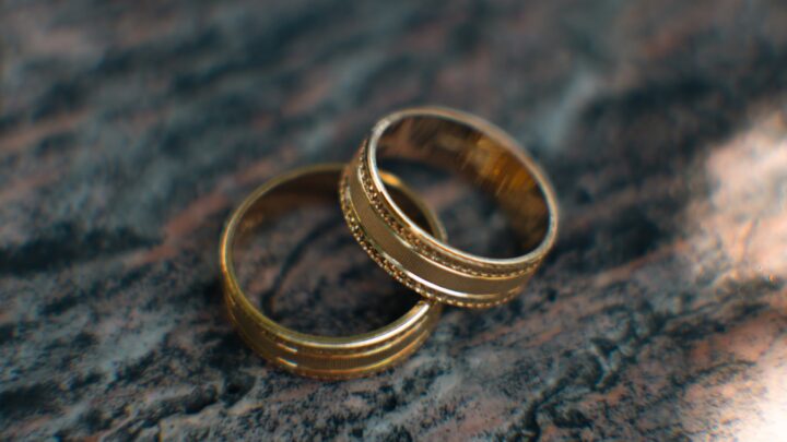 Two rings resting on a plain wooden surface