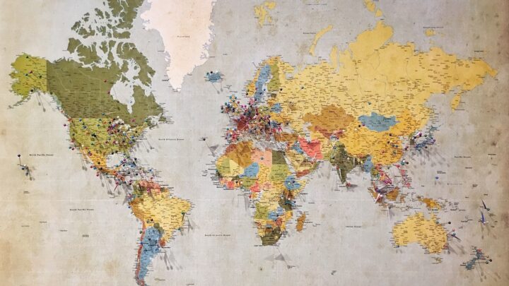 A world map beside banknotes from several countries