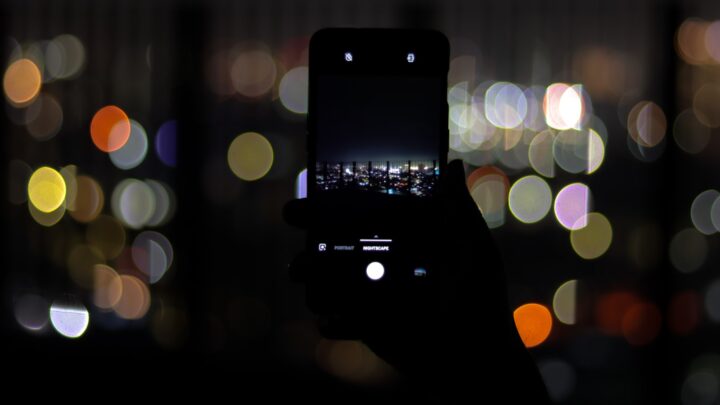 A person looking at a mobile phone screen in low light