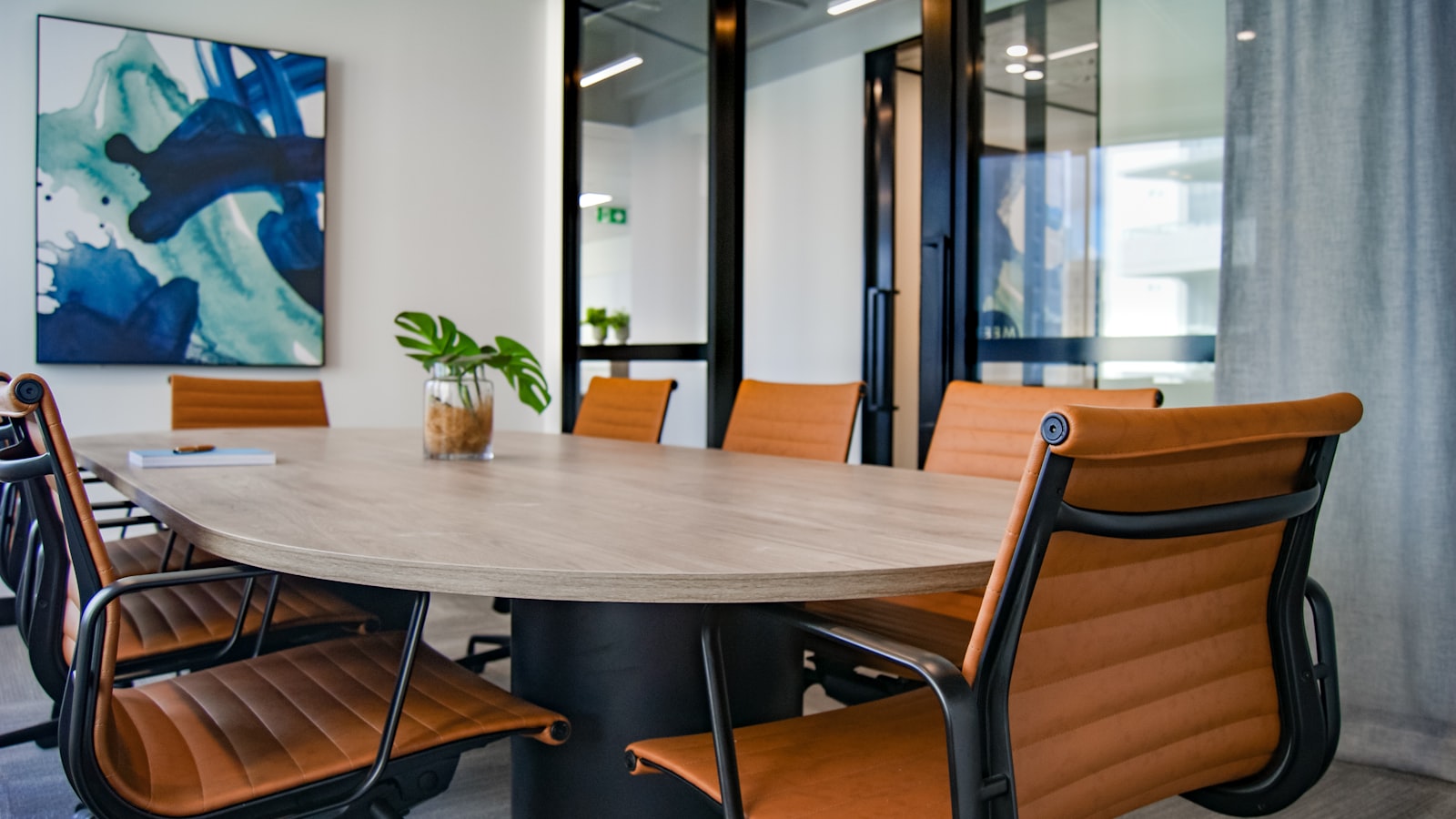 A round wooden table surrounded by empty chairs