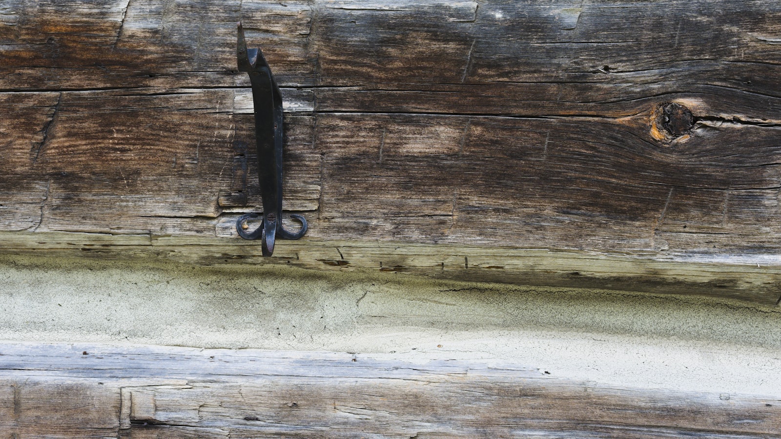 An aged brass key resting on a dark wooden surface