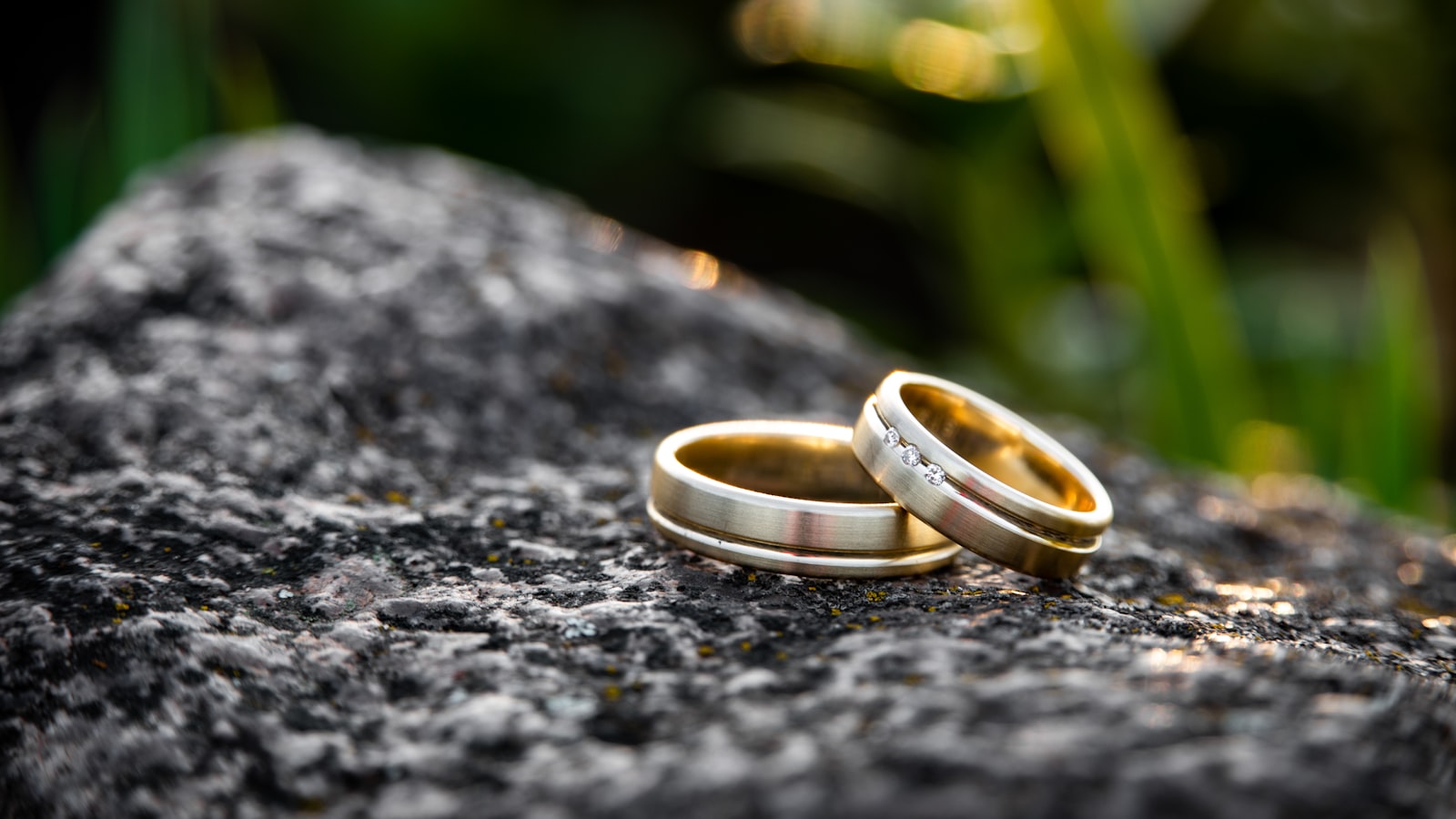 Two plain metal bands resting on a stone surface