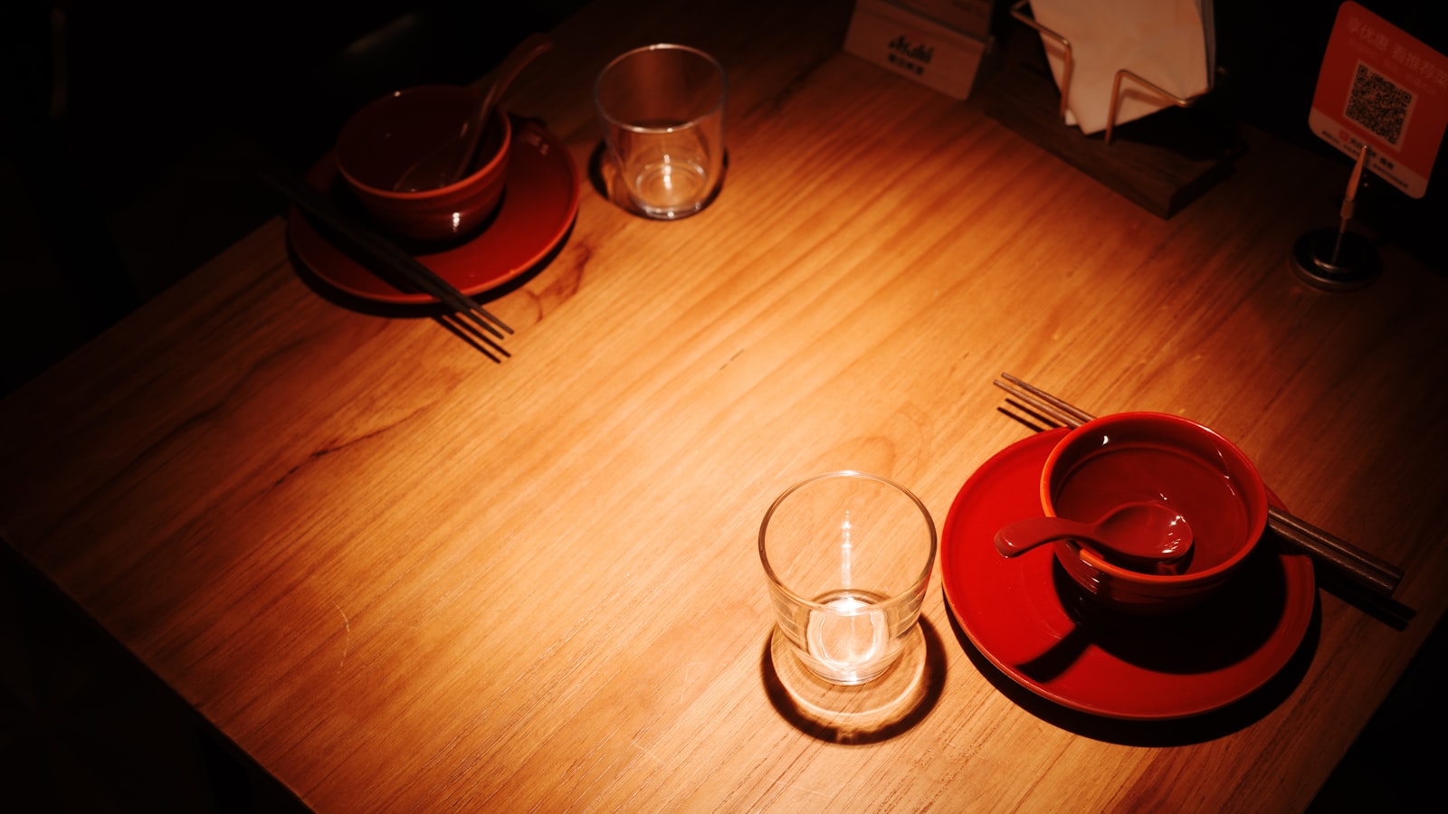 Two cups of tea on a wooden table by a window