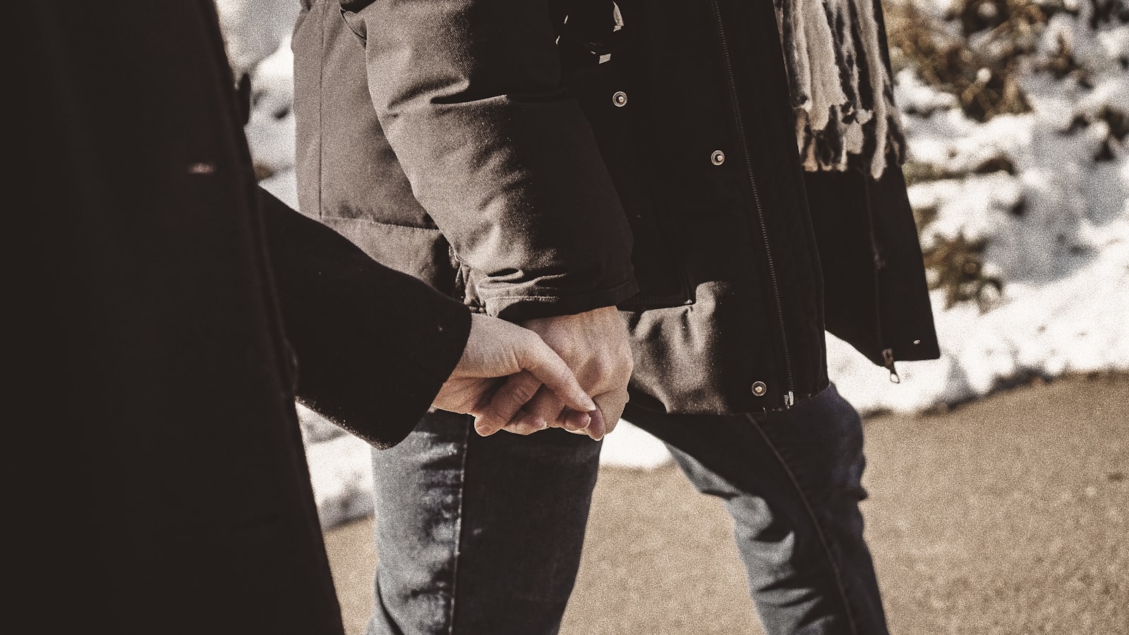 An adult and a small child holding hands outdoors