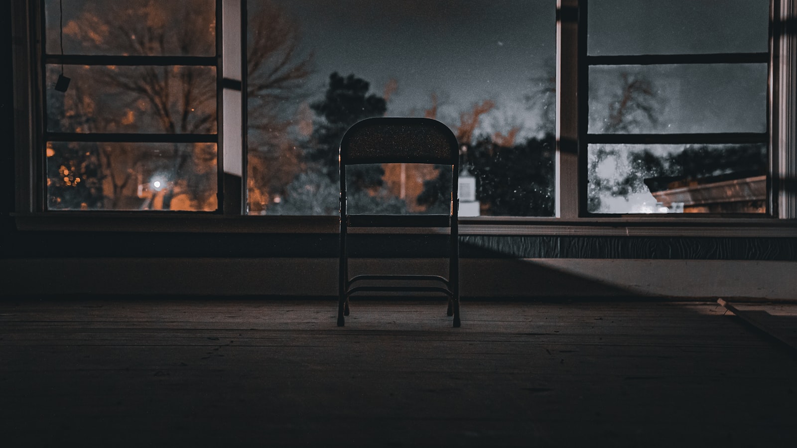 An empty office chair next to a window with morning light